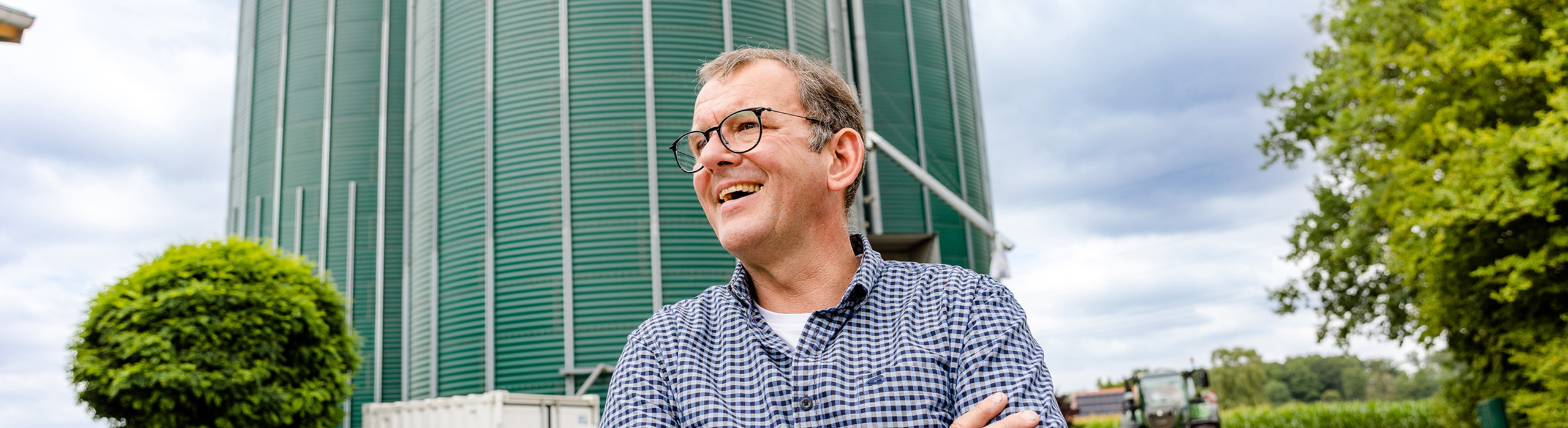 Herr Bischof vor großem Futtermittel-Silo/Getreidespeicher - Ihr Futtermittelexperte aus Dissen, Schüttorf & Warburg